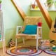 colorful room with eclectic design, circular rugs, plants, and a guitar