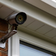security camera mounted to the side of the house.
