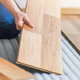 hands installing laminate wood flooring