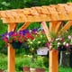A wooden pergola with hanging flowerpots.