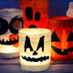 lighted halloween mason jars with colorful tissue and cutout shapes