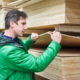 a man inspecting a stack of plywood