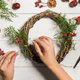 hands assembling holiday wreath