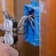 hands wiring an electrical outlet in an unfinished wall