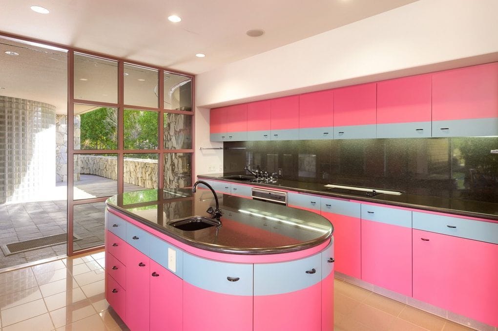 A bright pink kitchen decorated in the iconic style of the 1980s.