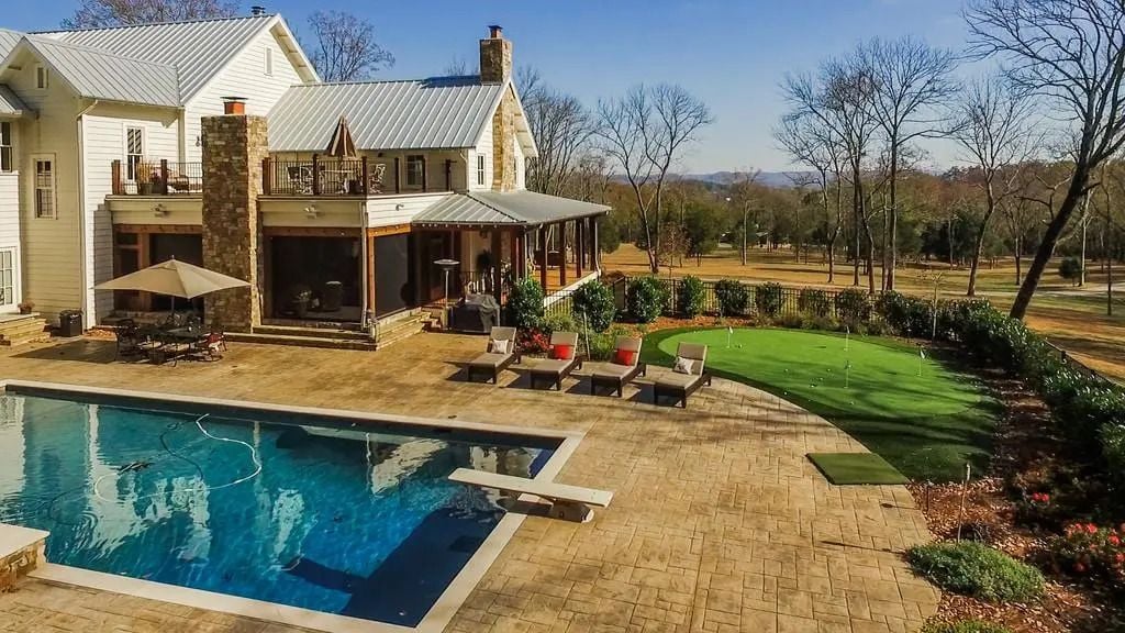 In-ground pool and small putting green in the back of Miley Cyrus' Nashville ranch.