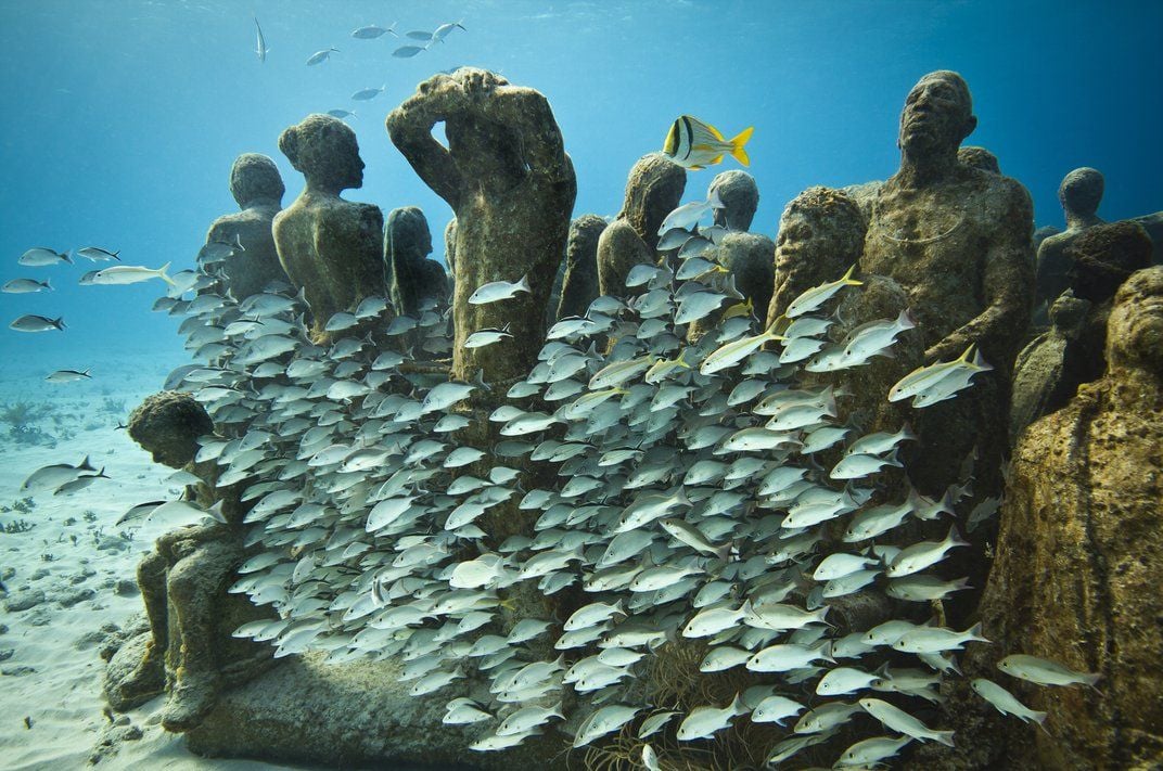 A school of fish swims through MUSA sculptures.