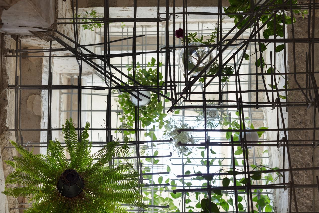 Exposed rebar and hanging plants in the atrium of MAMM Design's renovated Tokyo residence. 