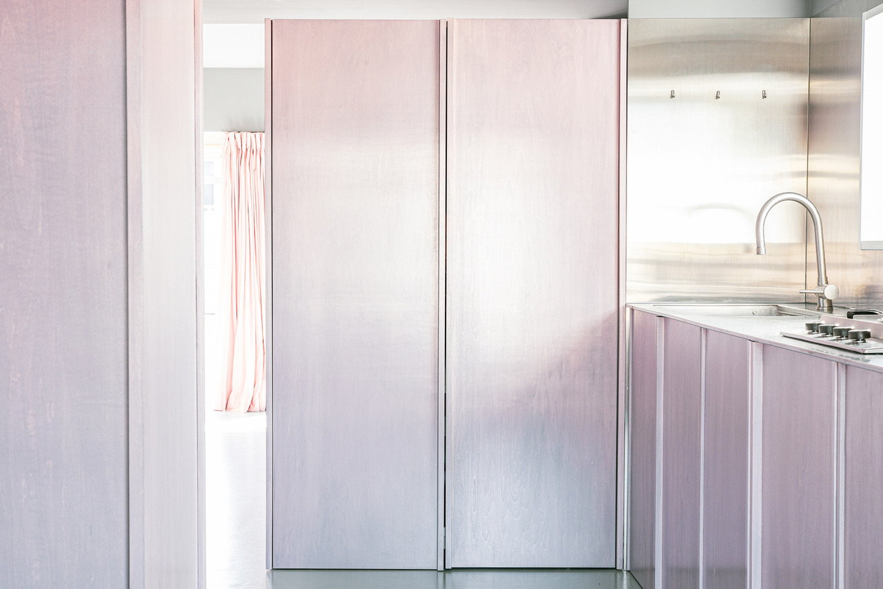 Pastel pink wall panels like these hide many of the rooms in the 404 Apartment and add to the illusion of more space.