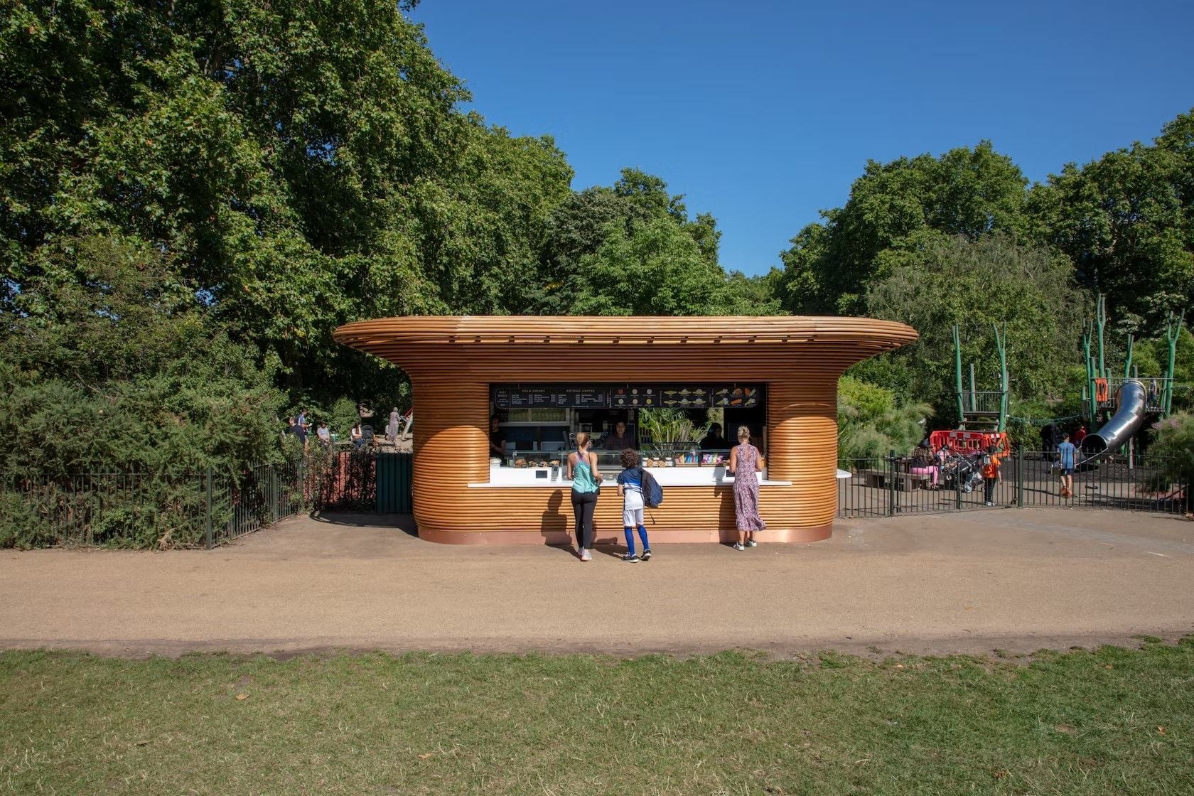 A Mizzi Studio-designed refreshment kiosk near a playground in one of London