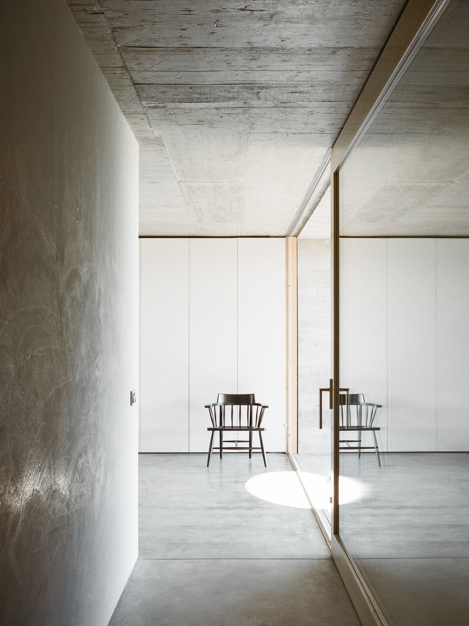 A sleek minimalist hallway inside the Casa na Terra, complete with lots of reflective surfaces. 