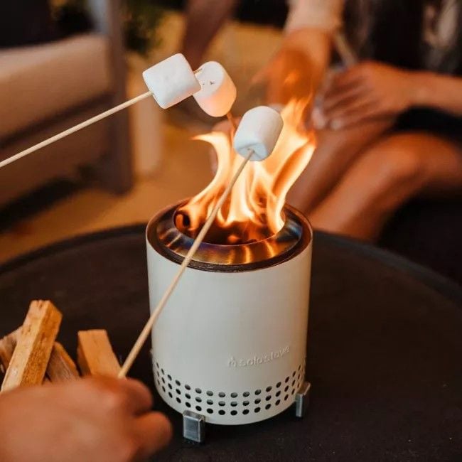 Friends roast s'mores around the compact Mesa tabletop fire pit.