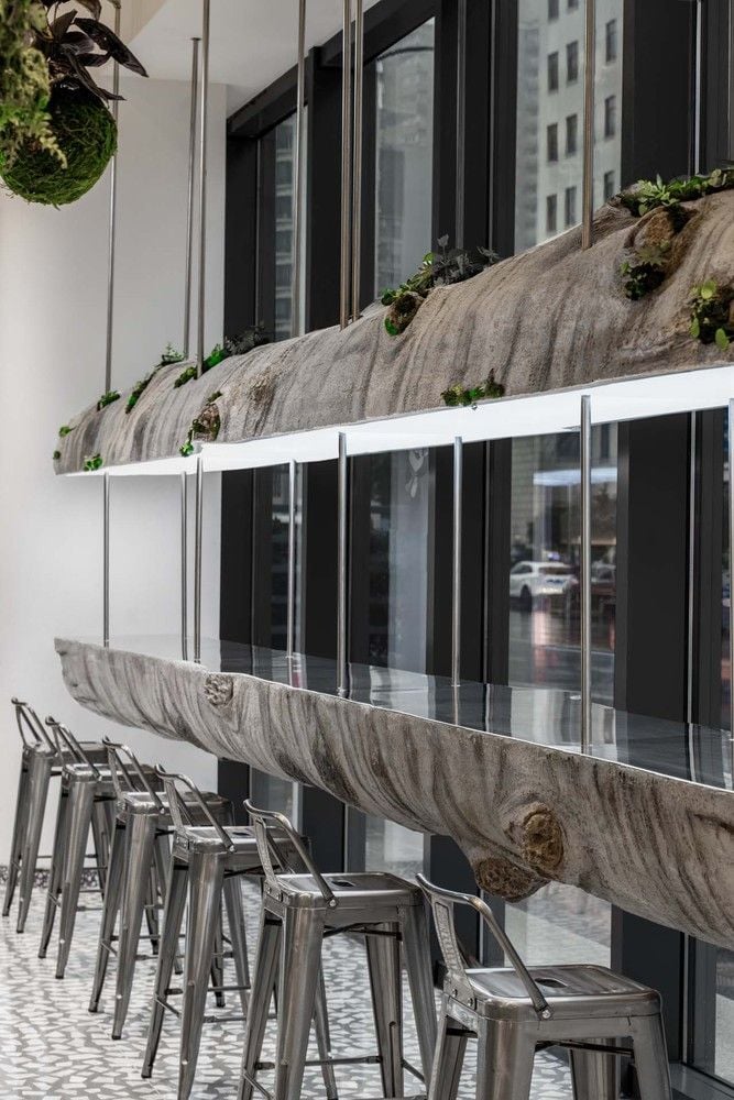 Suspended bisected log serves as another long table inside Shanghai's Metal Hands Coffee Shop.