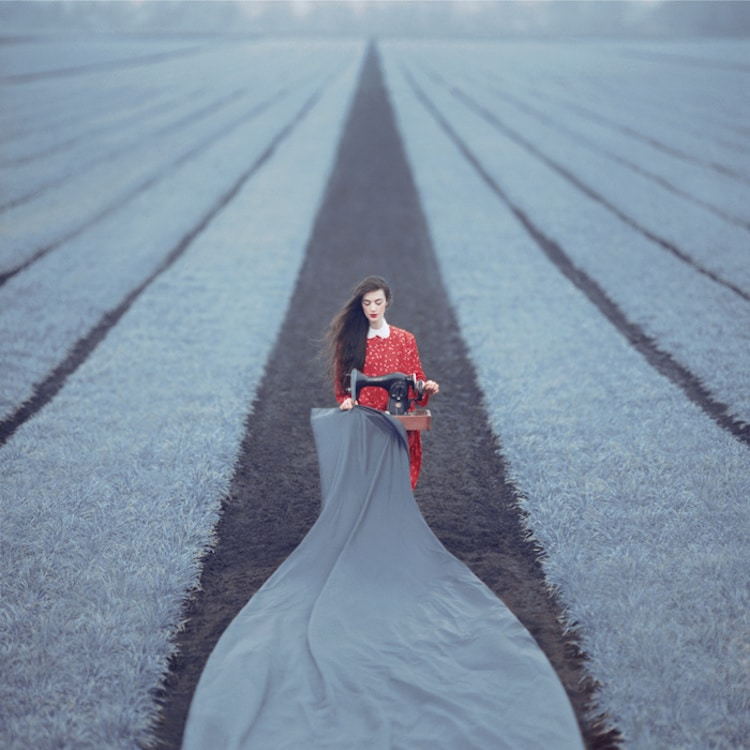Surreal photograph by Ukrainian artist Oleg Oprisco shows a woman standing in the middle of a field.
