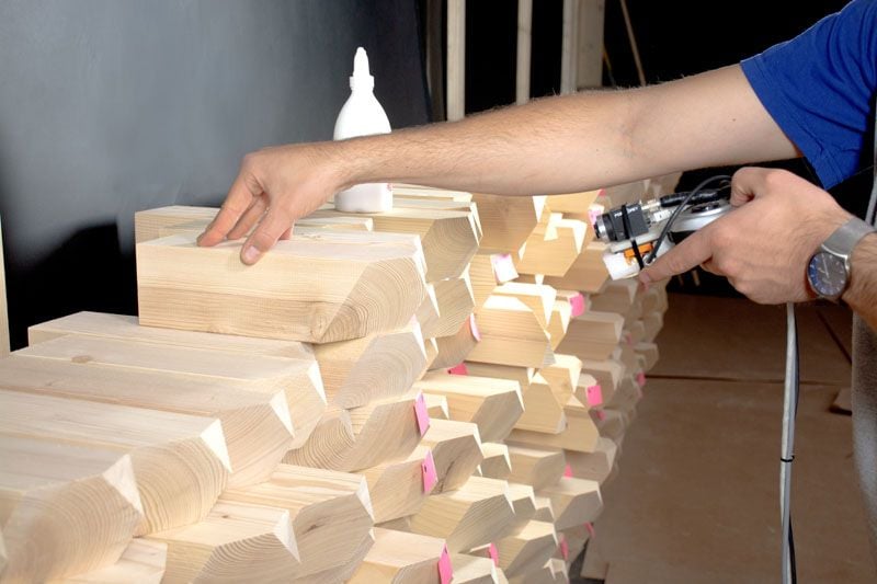 Carpenters use robotic cameras to properly assemble a modular acoustic timber wall