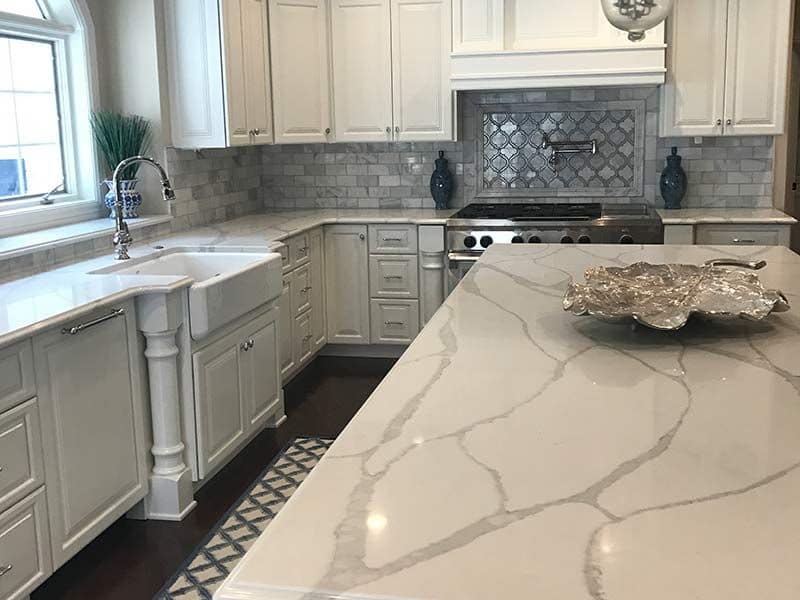 Large gray veins run through the marble countertop in this contemporary kitchen space. 
