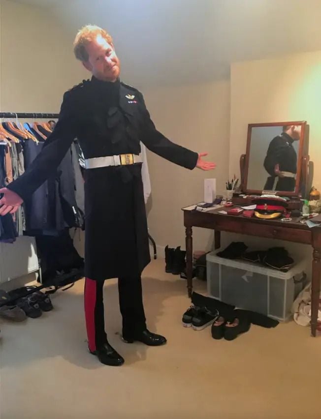 Prince Harry dons his officer's uniform in front of a small clothing rack at his Nottingham Cottage home.