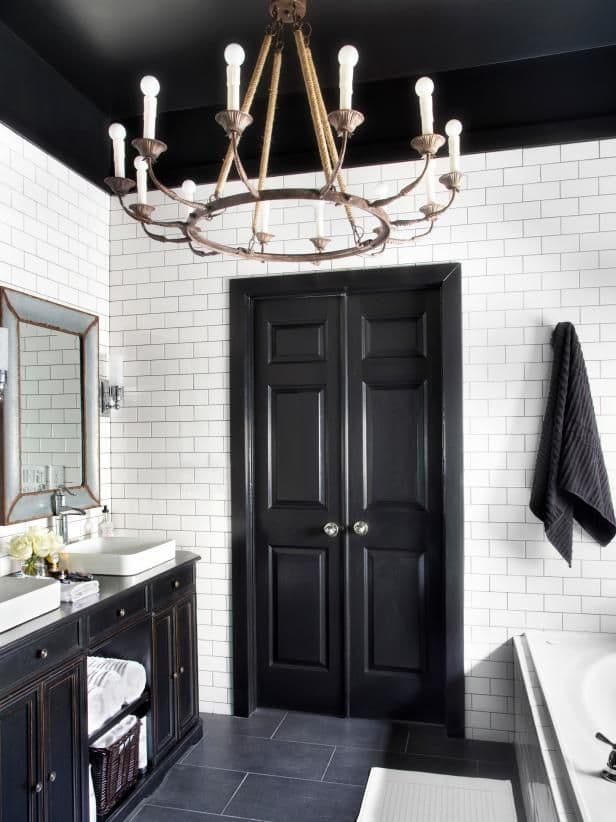 Dramatic black features like this door create a great sense of contrast with mostly white bathroom interiors.