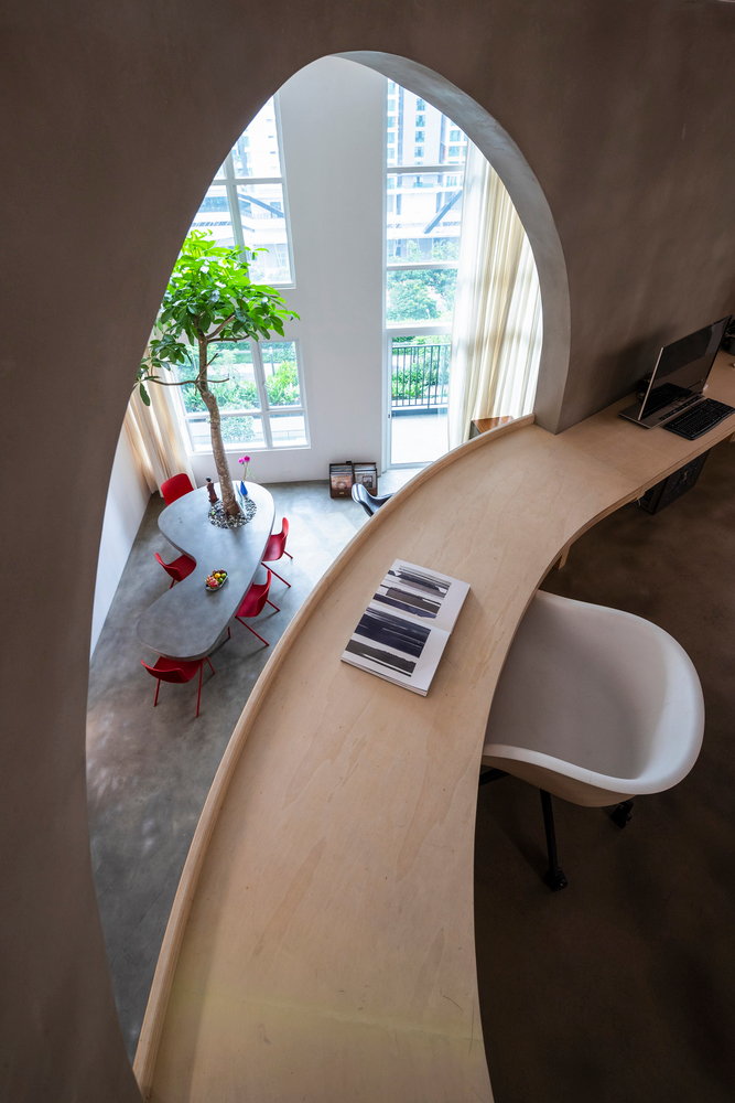 A sleek built-in wooden desk looks out over the Mai Apartment's minimalist dining space. 
