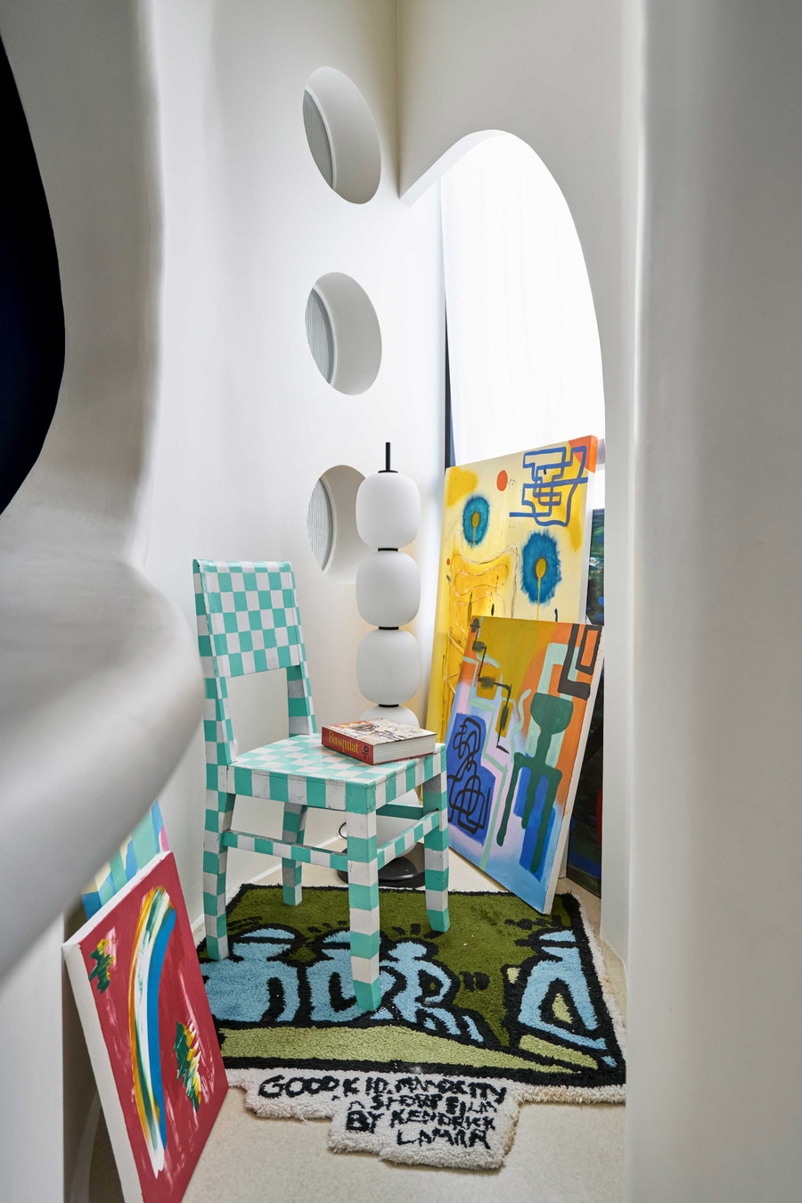 Colorful chairs, rugs, and artworks pop against the Dreamscape apartment's white walls and floors.