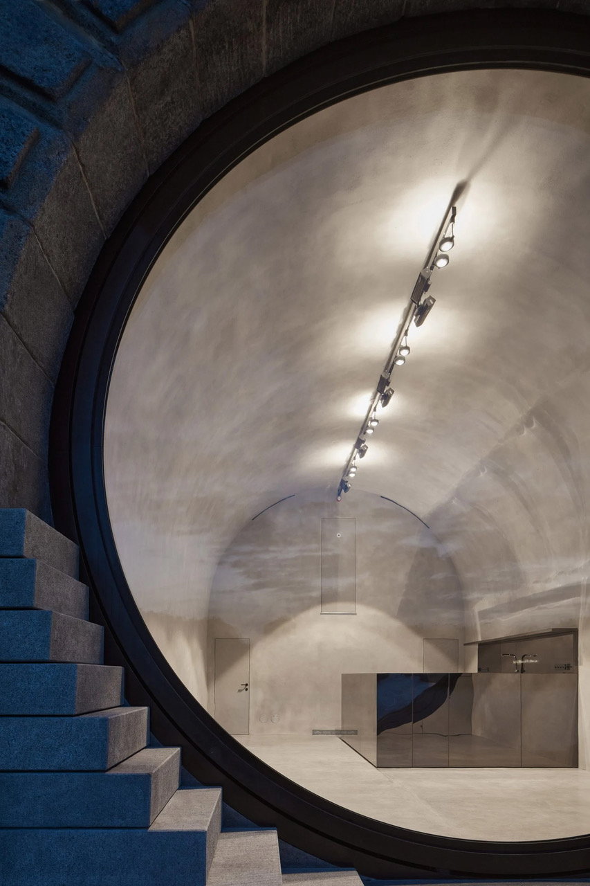 View through the large operable window into the minimalist interiors of a Brainwork Studio-restored Vltava River Vault. 