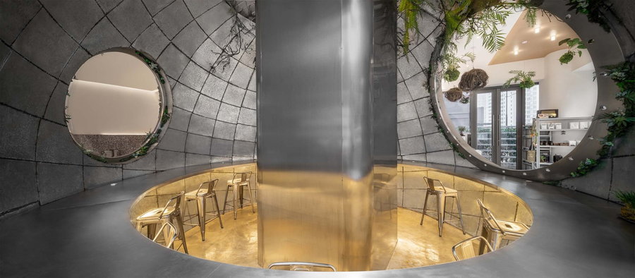 Bar-style seating wraps all around the inside of the Metal Hands Coffee Shop's central space capsule.