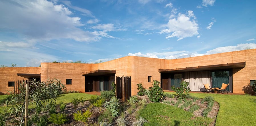 Front view of a couple of the rammed earth guest houses that make up the large zig-zagging 