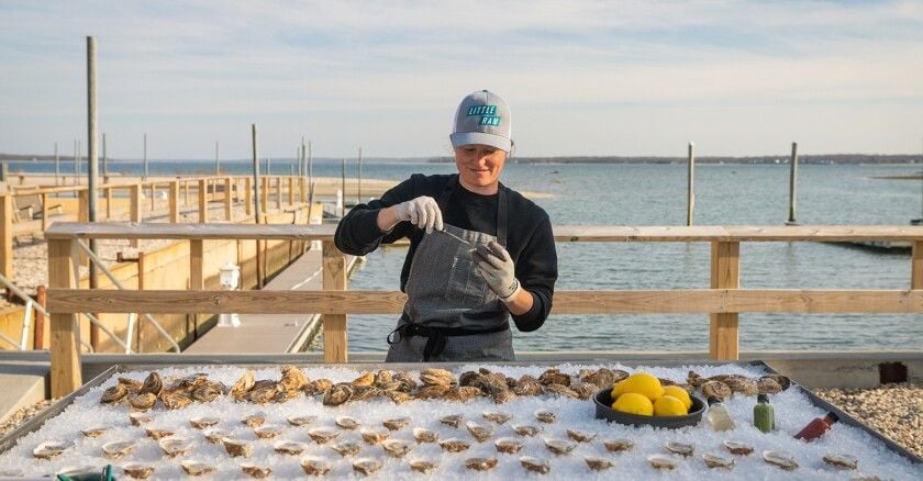 Little Ram Oyster Company employee serves up fresh oysters outside the Shoals.
