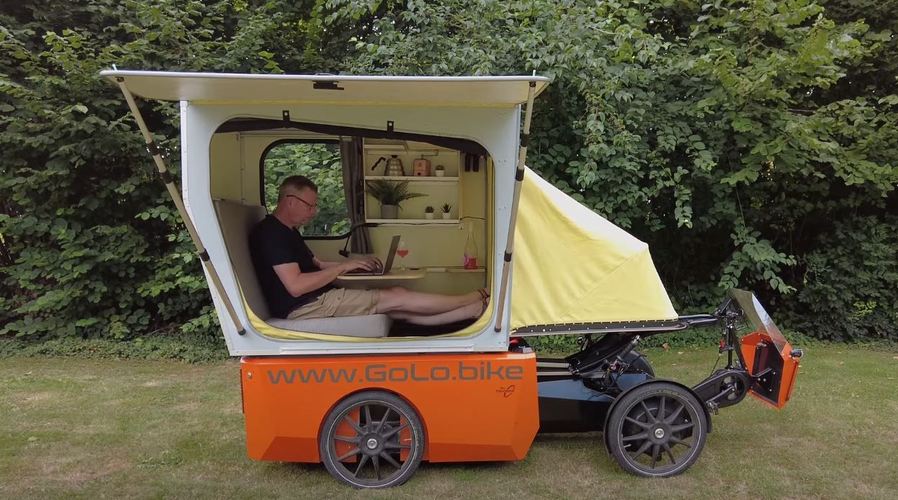 Man works on his laptop inside the GoLo GoCamp's attached RV module.