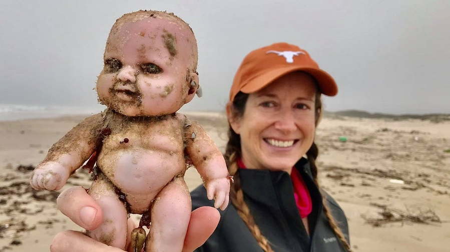 Texas native holds up a creepy doll washed up on the shores of the state's Coastal Bend.
