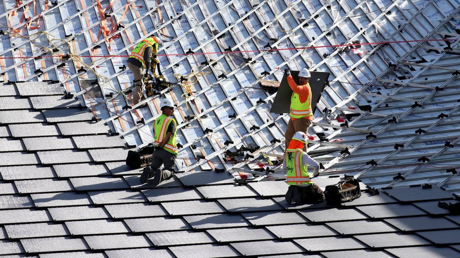 Workers install the Dragonscale solar panels on the rooftops of Google's new Bay Area campuses.