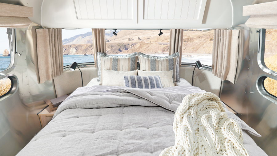 When it's time to call it a day, the Airstream X Poterry Barn Travel Trailer's cozy couch turns into this luxurious-looking bed. 
