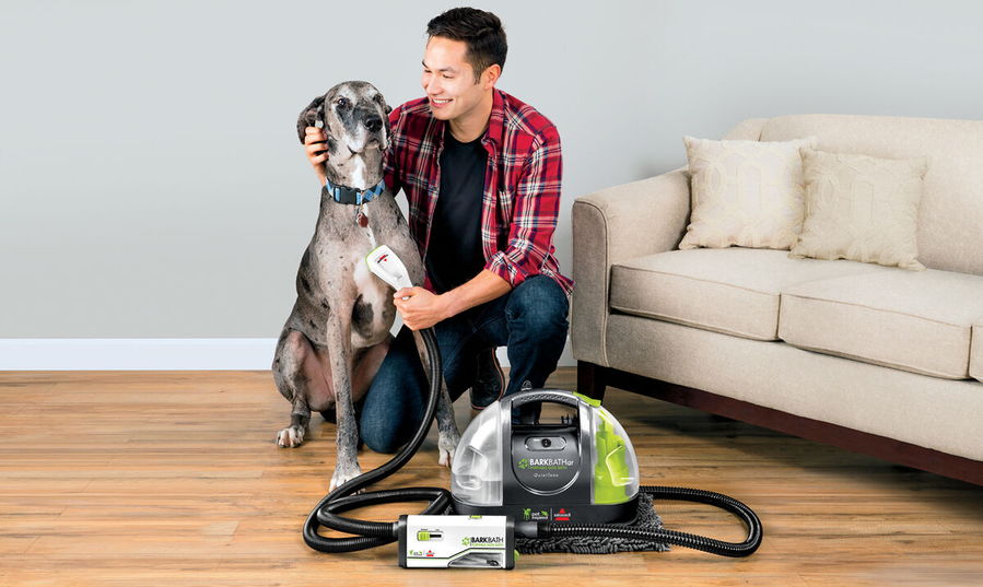 Pet owner grooms his dog using the gentle Bissell BarkBath.