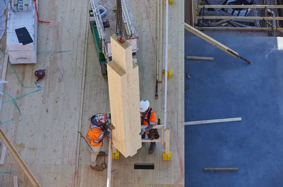 Construction workers erect a wooden pillar as part of the new Apex Plaza HQ in Charlottesville, Virginia.
