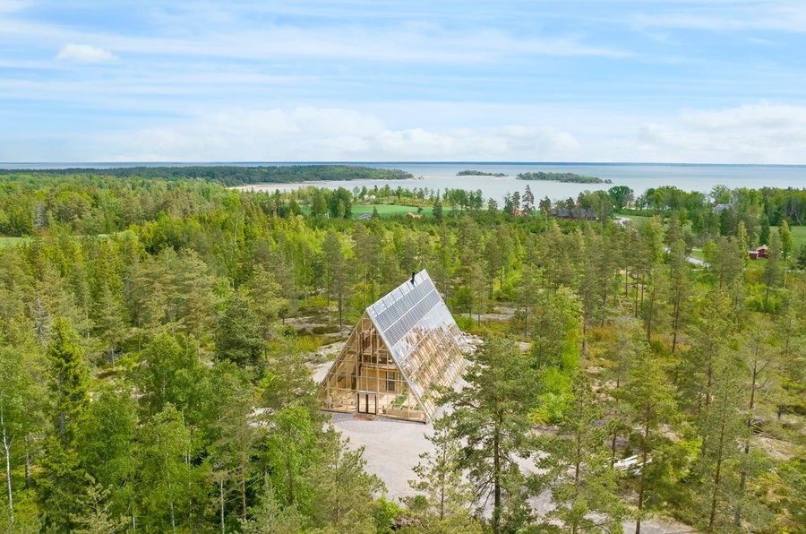 Sweden's off-grid Atri A-frame greenhouse home in the context of its natural surroundings. 