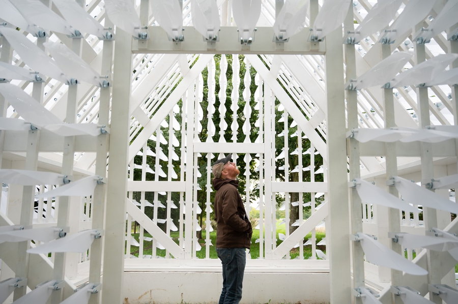 Man looks up inside the Shiver House kinetic structure.