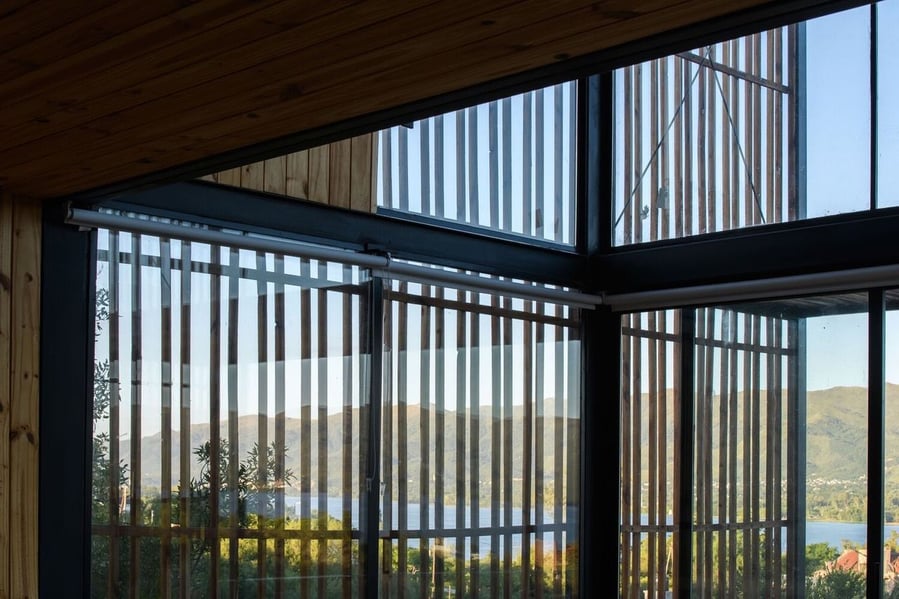 Screened walls of wood and glass line the entire Bioclimatic House. 