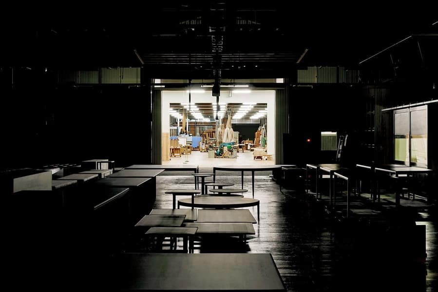 Inside a Time & Style manufacturing facility, with wooden tables strewn all throughout.