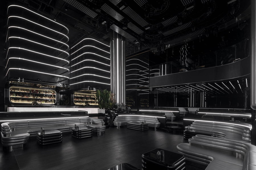All-black, multi-level seating and bar area in Shanghai's GRNDCNTRL nightclub. 