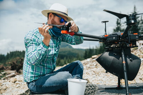 Volunteer readies a Flash Forest drone for take-off.  