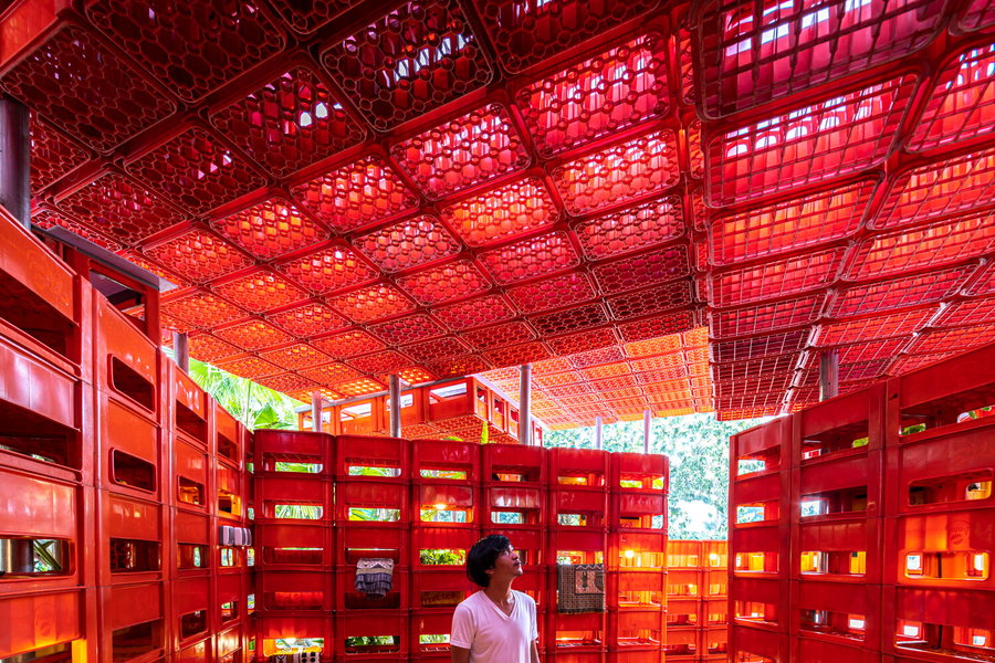 A young man stands inside the crate-made Kotakrat Pavilion