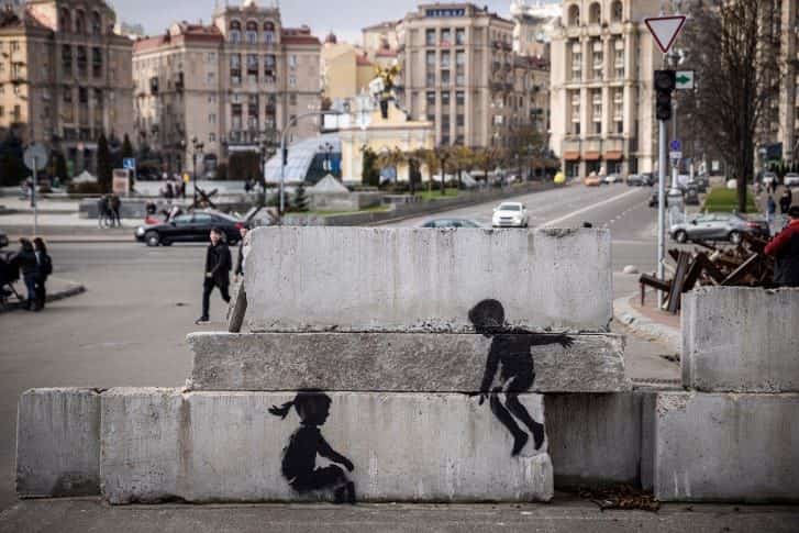Banksy mural in Borodyanka, Ukraine depicts children playing on a seesaw made from part of a tank.
