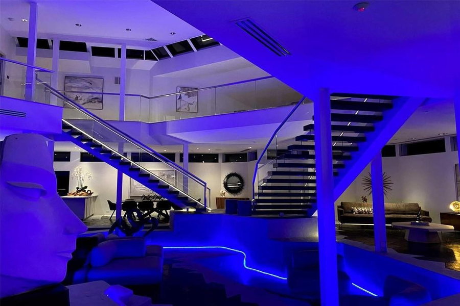 The main atrium of the Darth Vader House emits a soft blue glow at night.