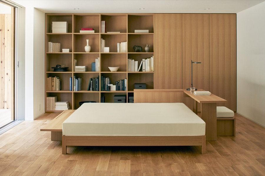 Custom shelving and a MUJI platform bed perfectly complement the streamlined look of the prefab's bedroom.