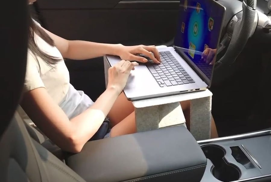 Person uses the iSwift M portable laptop desk to prop up their computer in a car.