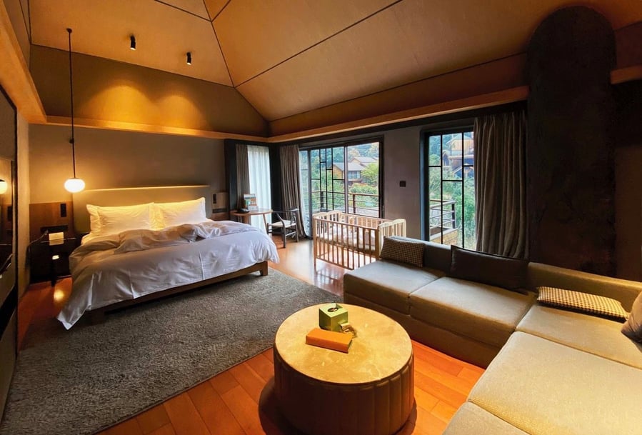View of a sleek, cozy bedroom inside one of the WH Studio-designed stacked treehouse cabins at China's Xiaoshan Xianghu resort.