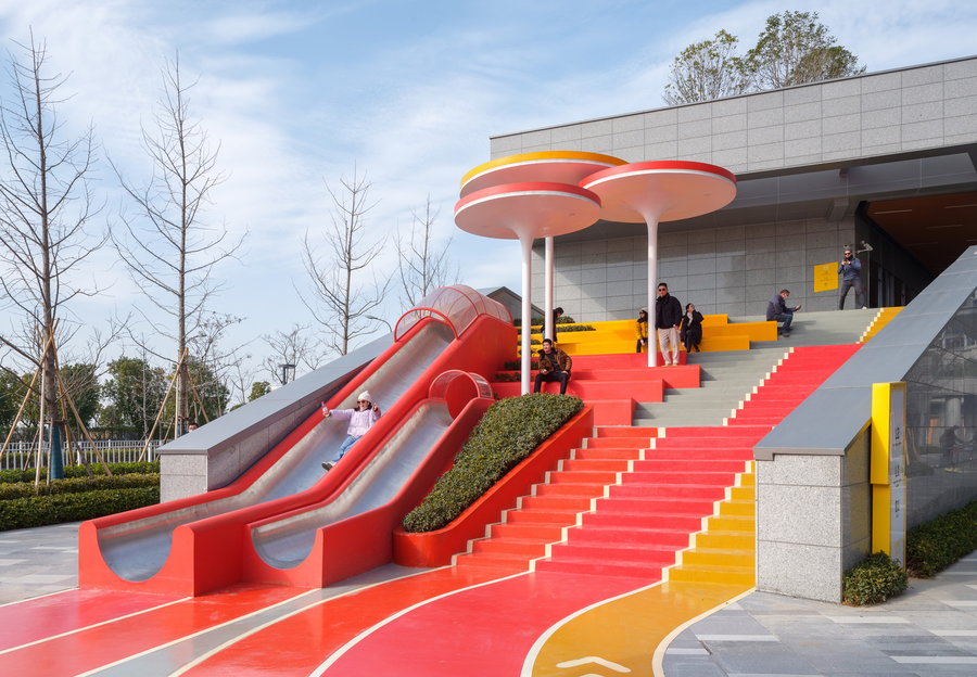 Families sit and play along the colorful steps at the new Magma Flow Park in Ningbo, China.