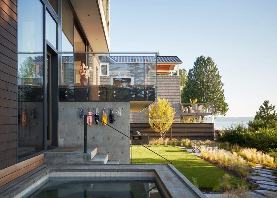 Luxurious upper-story balcony and swimming pool elevate the Fauntleroy Residence's cozy backyard area.