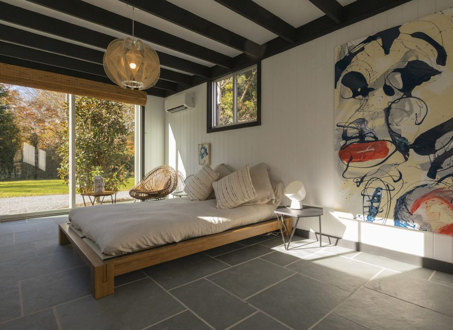 Open, light-feeling bedroom space inside the Lisa Perry-restored Scull House in the Hamptons.