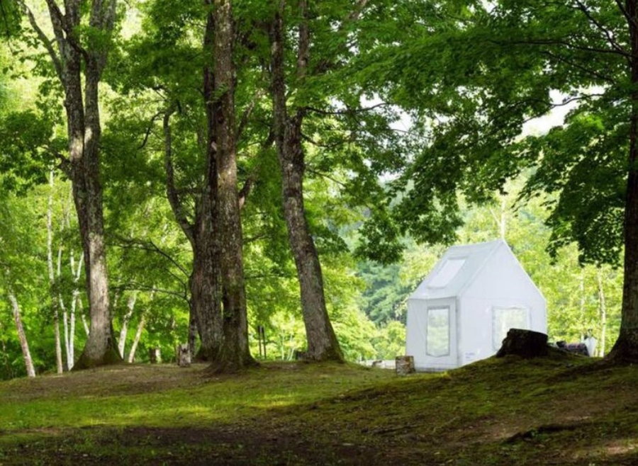 Air Architecture's white inflatable tent set up in the woods.